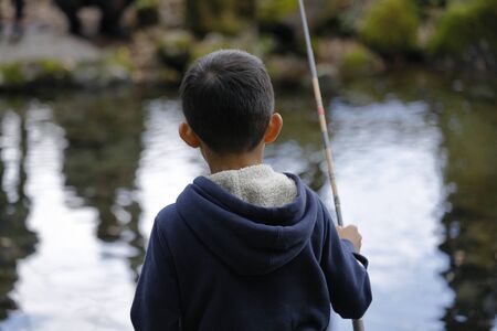 Japanese boy catching fish (fourth grade at elementary school)の写真素材