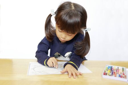 Japanese girl drawing a coloring book (4 years old)の写真素材