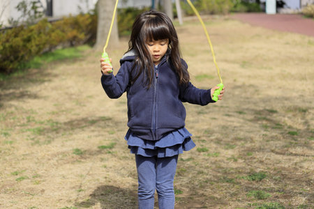 Japanese girl (5 years old) playing with jump ropeの写真素材