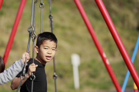 Japanese boy on the swing (fourth grade at elementary school)の写真素材