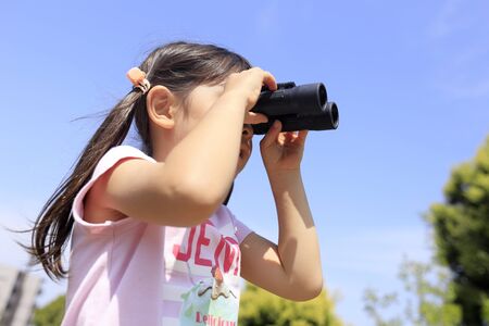 Japanese girl with opera glass under the blue sky (5 years old)の写真素材