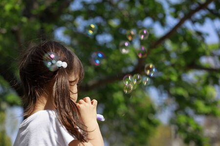 Japanese girl playing with bubble in the green (appearance from behind) (5 years old)の写真素材