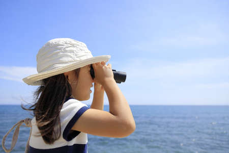 Japanese girl with opera glass at seaside (5 years old)の写真素材