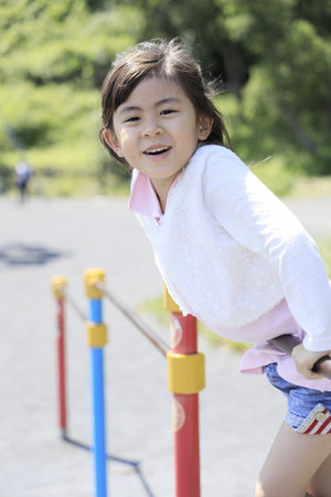 Japanese student girl playing with high bar (6 years old)の写真素材