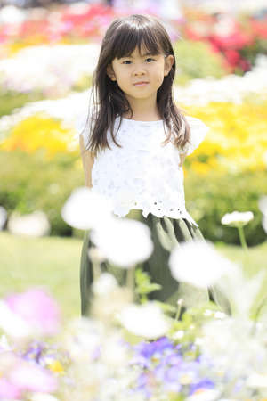 Japanese student girl in flower garden (6 years old)の写真素材