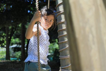 Japanese student girl playing at outdoor obstacle course (6 years old)