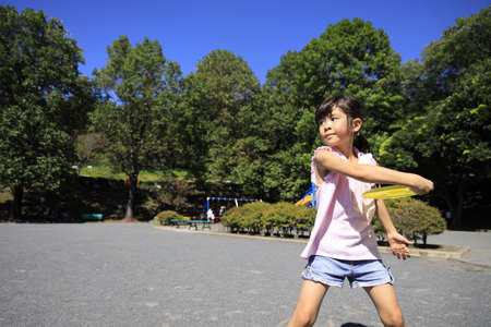 Japanese student girl playing flying disc (6 years old)の写真素材