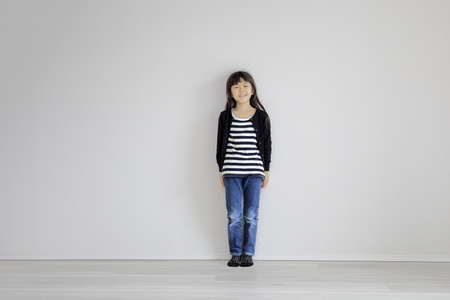 Japanese girl leaning on the wall (7 years old)の写真素材