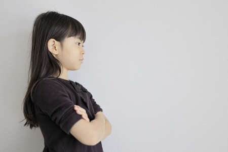 Japanese girl folding her arms (profile) (7 years old)の写真素材