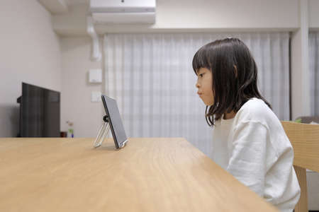 Japanese girl watching video on tablet PC (7 years old)の写真素材
