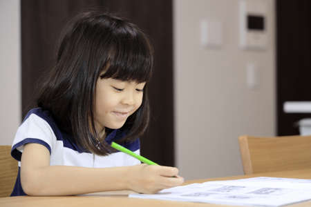 studying Japanese girl in dining room (7 years old)の写真素材
