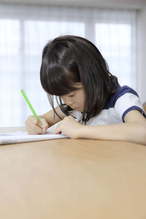 studying Japanese girl in dining room (7 years old)の写真素材