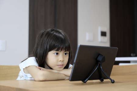 Japanese girl watching video on tablet PC (7 years old)の写真素材