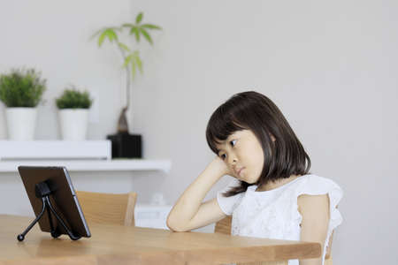 Japanese girl watching video on tablet PC (7 years old)の写真素材