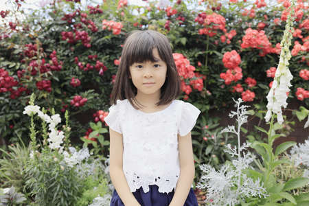 Japanese girl in flower garden (7 years old)の写真素材