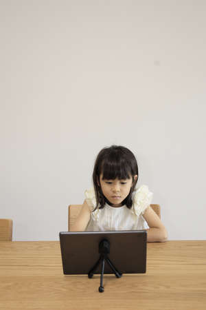 Japanese girl watching video on tablet PC (7 years old)の写真素材