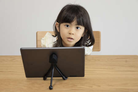 Japanese girl watching video on tablet PC (7 years old)の写真素材