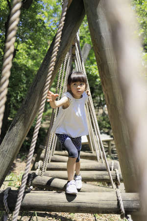 Japanese student girl playing at outdoor obstacle course (7 years old)の写真素材