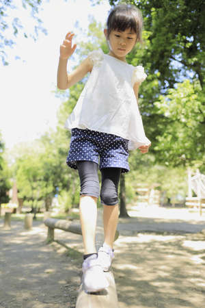 Japanese student girl on the balance beam (7 years old)の写真素材