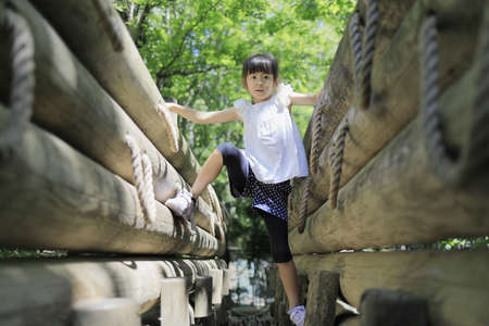 Japanese student girl playing at outdoor obstacle course (7 years old)の写真素材