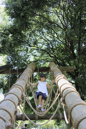 Japanese student girl playing at outdoor obstacle course (7 years old)の写真素材