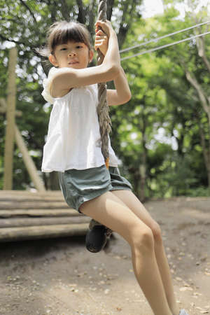 Japanese student girl playing with flying fox (7 years old)の写真素材