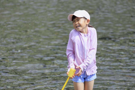 Japanese student girl playing in the river (7 years old)の写真素材