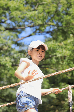 Japanese student girl playing with rope walking (7 years old)の素材 [FY310192254255]