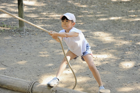 Japanese student girl playing at outdoor obstacle course (7 years old)の写真素材