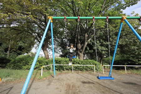Japanese student girl on the swing (8 years old)の写真素材