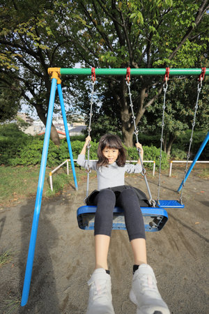 Japanese student girl on the swing (8 years old)の写真素材