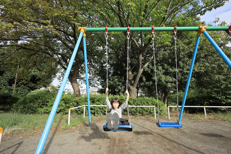 Japanese student girl on the swing (8 years old)の写真素材