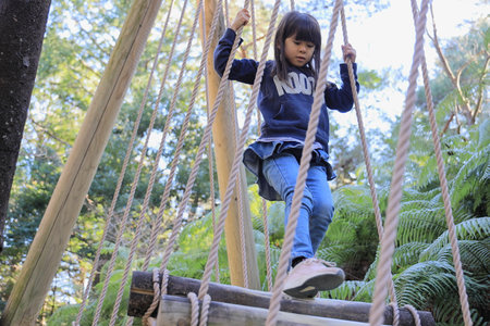 Japanese student girl playing at outdoor obstacle course (8 years old)の写真素材