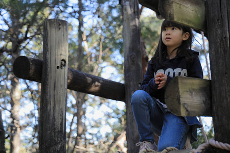 Japanese student girl playing at outdoor obstacle course (8 years old)の写真素材