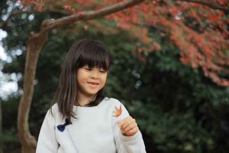 autumn leaves and Japanese student girl (8 years old)の写真素材