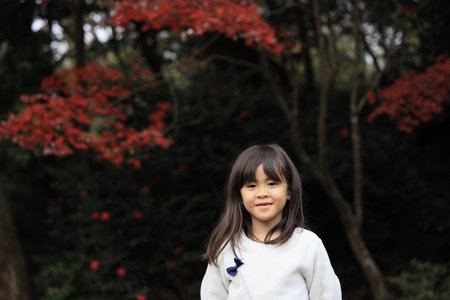 autumn leaves and Japanese student girl (8 years old)の写真素材
