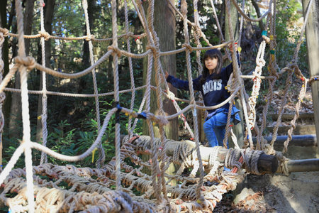 Japanese student girl playing at outdoor obstacle course (8 years old)の写真素材
