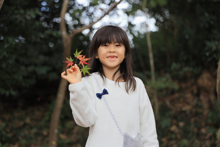 autumn leaves and Japanese student girl (8 years old)の写真素材
