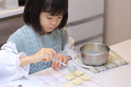 Japanese student girl cooking white chocolate (8 years old)の写真素材