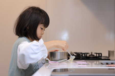 Japanese student girl cooking white chocolate (8 years old)の写真素材