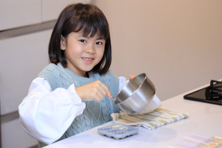 Japanese student girl cooking white chocolate (8 years old)の写真素材