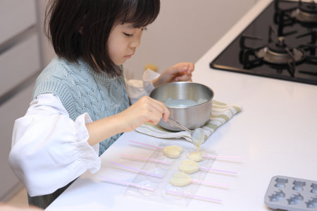 Japanese student girl cooking white chocolate (8 years old)の写真素材