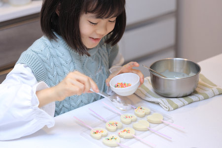 Japanese student girl cooking white chocolate (8 years old)の写真素材