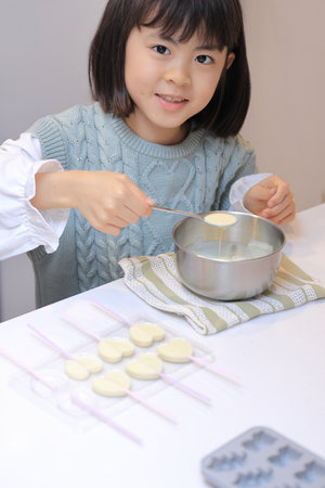 Japanese student girl cooking white chocolate (8 years old)の写真素材