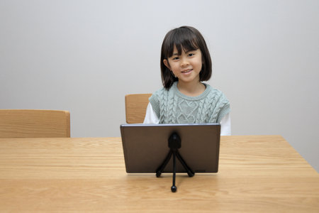 Japanese student girl watching video on tablet PC (8 years old)の写真素材
