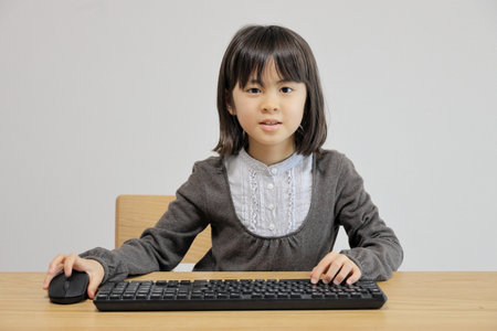 Japanese student girl using PC mouse (8 years old)の写真素材