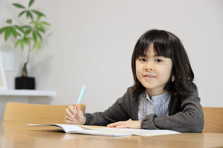 Japanese student girl studying in dining room (8 years old)
