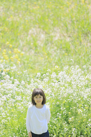 Japanese student girl in flower garden (8 years old)の写真素材