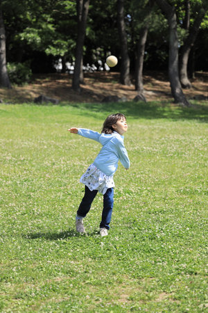 Japanese student girl throwing a ball (8 years old)の写真素材