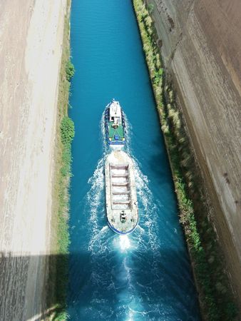 an aerial view of the Corinthia Canal in Greece with a boat passing throughの写真素材